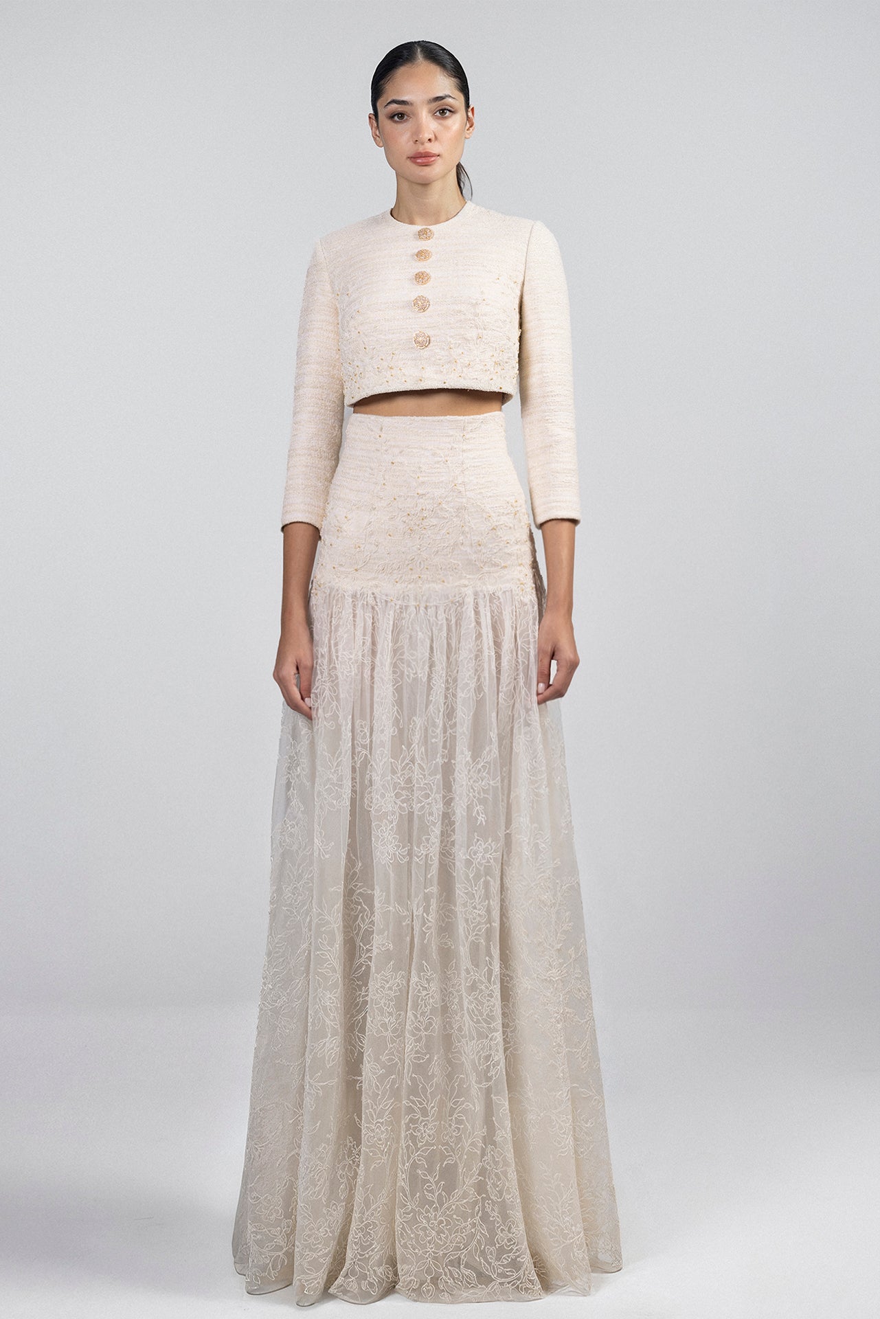 Load and play video in Gallery viewer, Ivory cropped jacket, round neck, crystal button front, paired with high-waisted floor-length skirt, fitted tweed waistband, lace embroidered skirt.