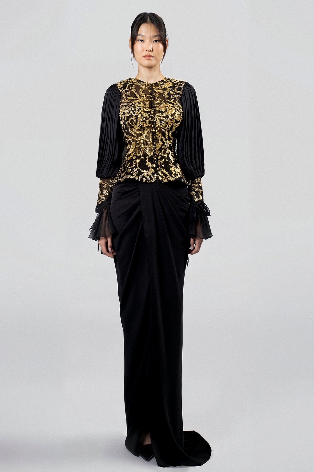 Load and play video in Gallery viewer, Gold embroidered mesh top, round neckline, black chiffon bishop sleeves, ruffled cuffs, paired with black crepe floor-length skirt, draped front, train.